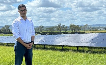 Associate Professor Rahul Sharma says SolarisAI could save solar farms millions of dollars by detecting faulty and underperforming panels in real-time. A man stands in a grassy field with rows of solar panels behind him.